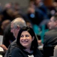 Shorouq Almallah and unknown person listening to the West Michigan Economic Forecast